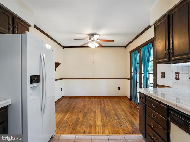 4216 Valley Vista Ct, Manchester, MD 21102 - kitchen with ceiling fan, dark brown cabinetry, tile countertops, light wood-style floors, and white appliances