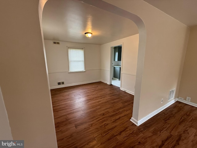 3750 Derry St, Harrisburg, PA 17111 - empty room featuring arched walkways, visible vents, and dark wood finished floors