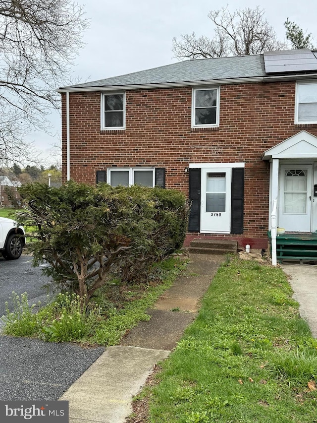 3750 Derry St, Harrisburg, PA 17111 - view of front of home featuring roof with shingles, brick siding, and roof mounted solar panels