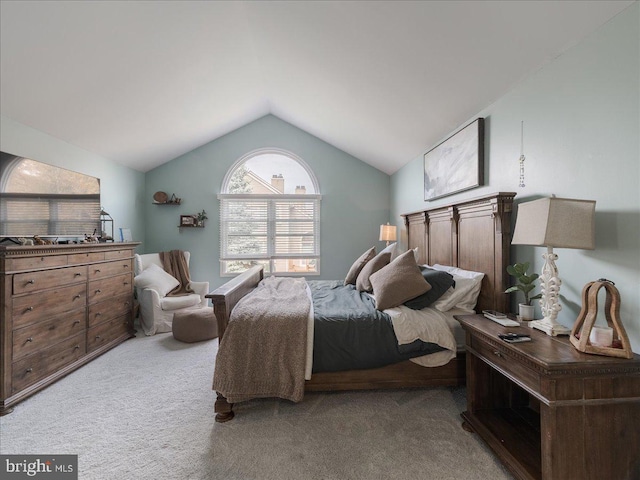 bedroom featuring light colored carpet and lofted ceiling