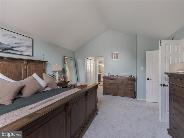 bedroom with baseboards, vaulted ceiling, light carpet, ensuite bathroom, and visible vents