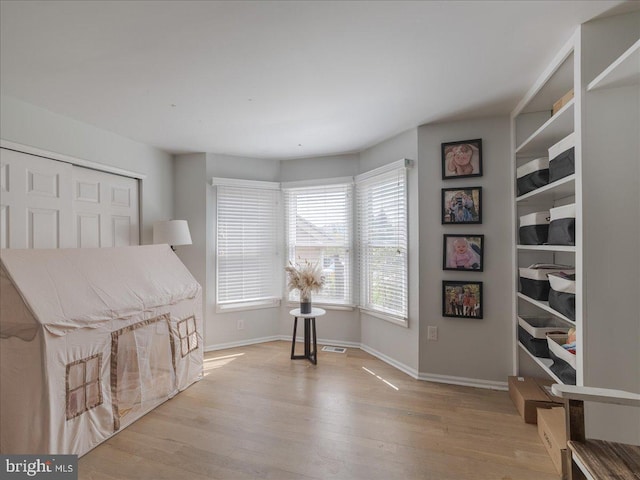 living area featuring light wood finished floors and baseboards