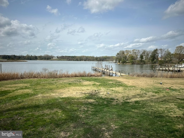 dock area with a lawn and a water view