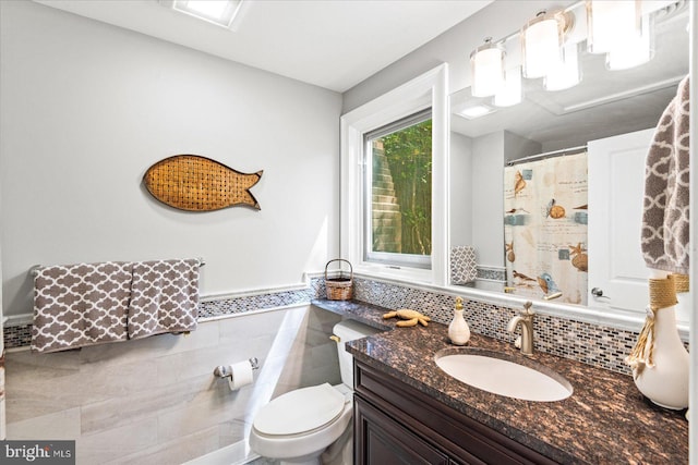 full bathroom with vanity, a shower with shower curtain, tasteful backsplash, and toilet