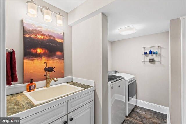 laundry room featuring separate washer and dryer, baseboards, a sink, and laundry area