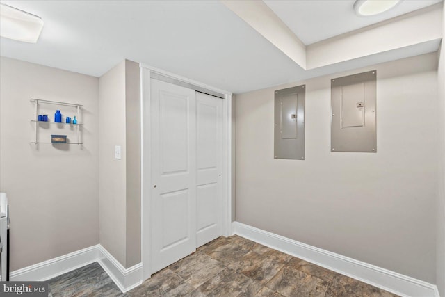 corridor featuring electric panel and baseboards