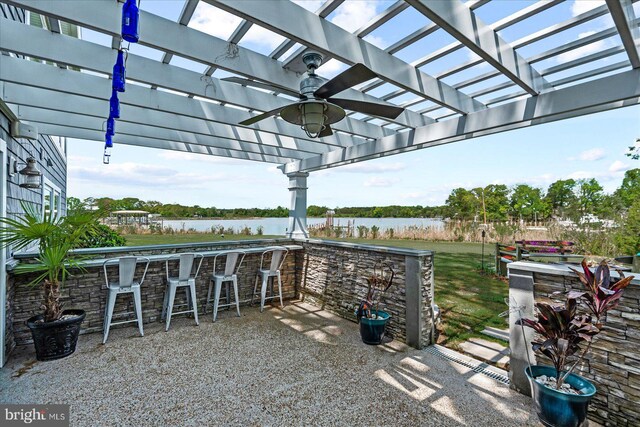 view of patio / terrace with outdoor dry bar, a pergola, a water view, and ceiling fan