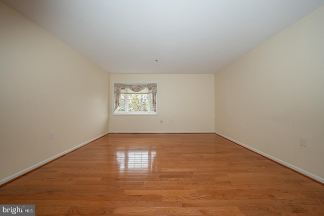 spare room with light wood-style flooring and baseboards