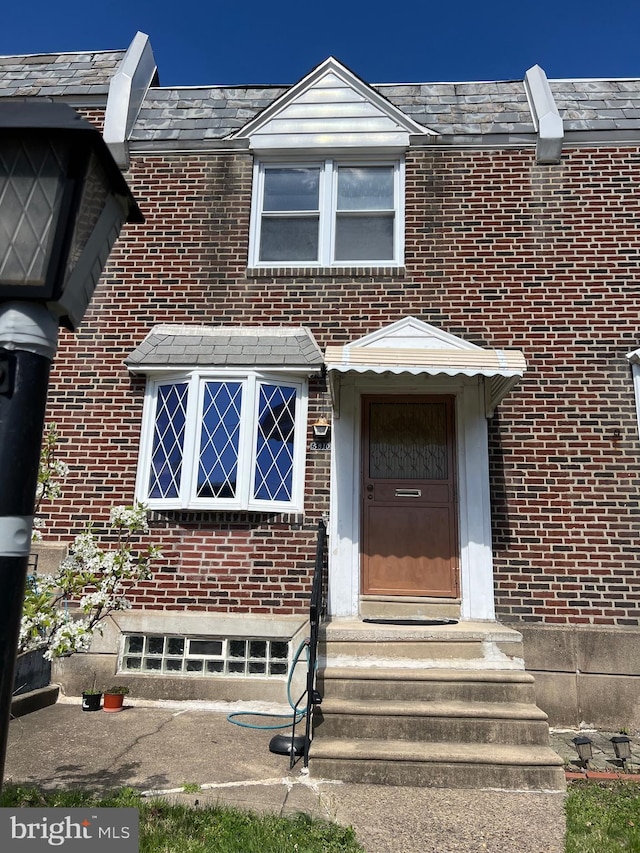 view of exterior entry featuring brick siding
