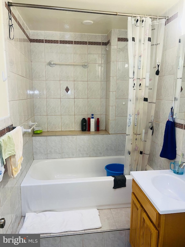 full bathroom with tile patterned floors, vanity, shower / tub combo with curtain, and tile walls