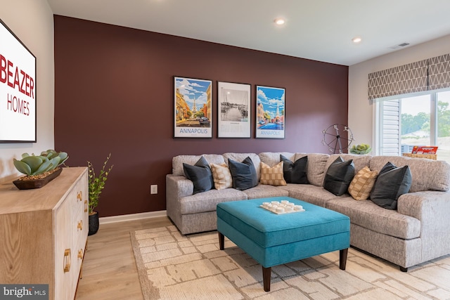 living room featuring visible vents, baseboards, light wood finished floors, and recessed lighting