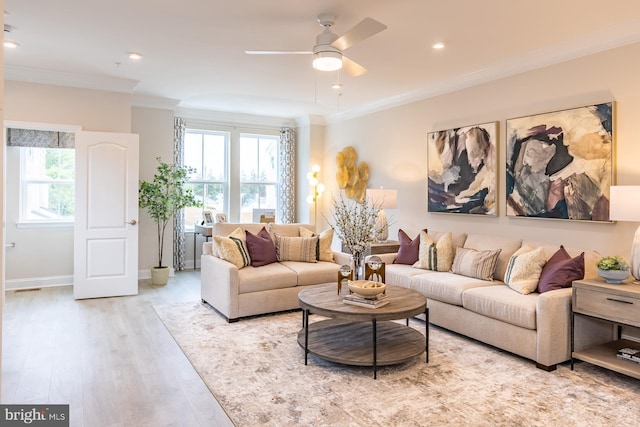 living area with wood finished floors, ceiling fan, baseboards, and ornamental molding