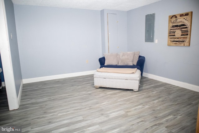 10861 Smugglers Notch Ct, White Plains, MD 20695 - living area with wood finished floors, electric panel, baseboards, and a textured ceiling