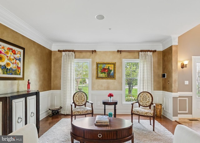 sitting room with crown molding, a healthy amount of sunlight, and wood finished floors