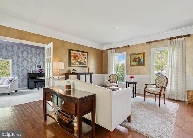 living area with ornamental molding, a wainscoted wall, wood finished floors, and wallpapered walls