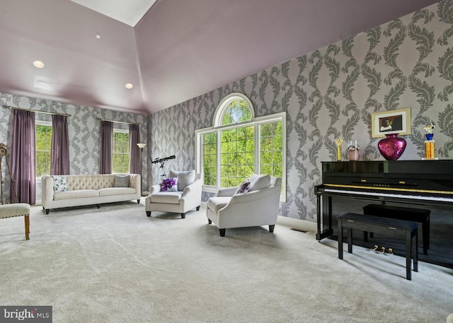 living area featuring wallpapered walls, vaulted ceiling, and carpet floors