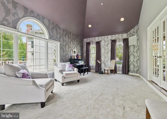 sitting room featuring a healthy amount of sunlight, french doors, wallpapered walls, and carpet