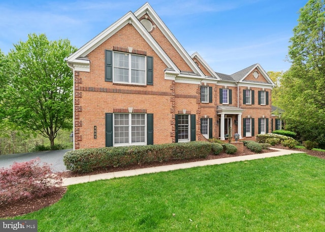 view of front of property with a front lawn and brick siding
