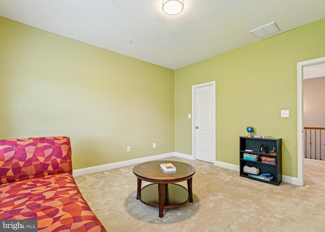living area with baseboards, visible vents, and carpet