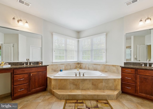 full bath featuring a garden tub, two vanities, a sink, and visible vents