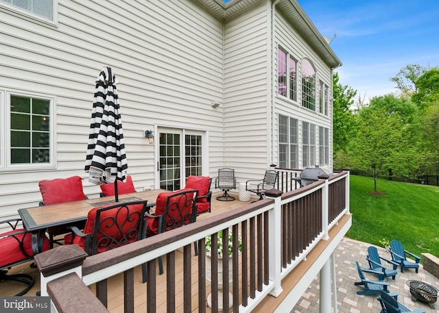 wooden deck with outdoor dining space and a lawn