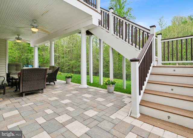 view of patio with outdoor dining space, stairs, and ceiling fan