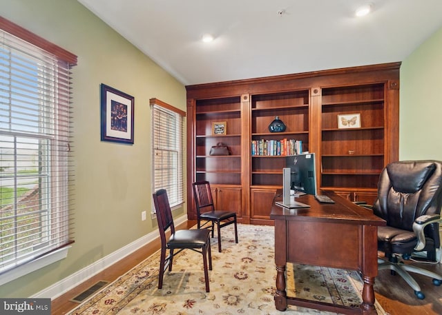 office featuring wood finished floors, visible vents, and baseboards