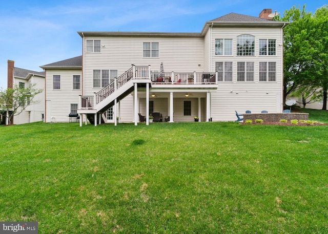back of house featuring a wooden deck, a chimney, a yard, and stairs