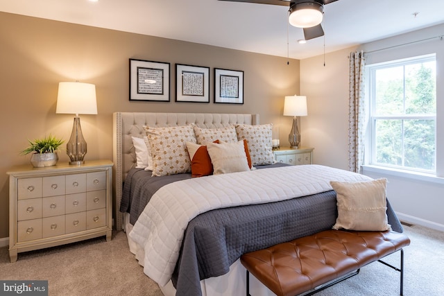 bedroom featuring baseboards, light carpet, a ceiling fan, and visible vents