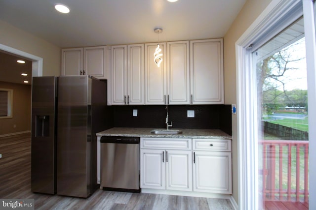 2214 Wintergreen Ave, District Heights, MD 20747 - kitchen featuring tasteful backsplash, light wood-type flooring, a sink, and stainless steel appliances