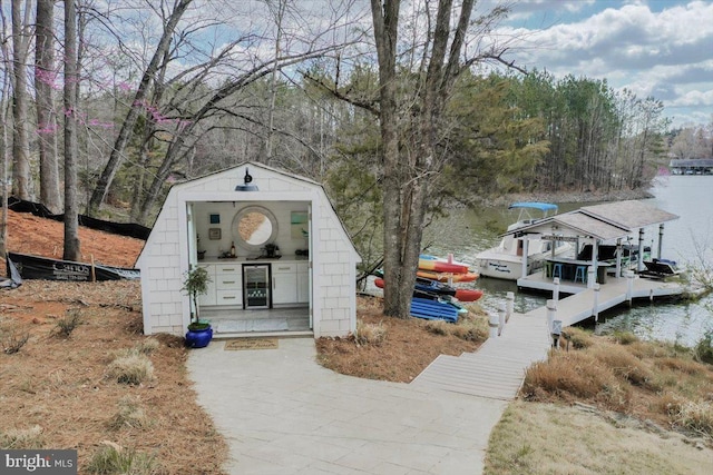 exterior space with a view of trees, a water view, and a boat dock