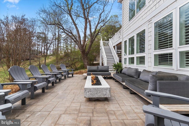 view of patio / terrace featuring an outdoor living space with a fire pit and stairs