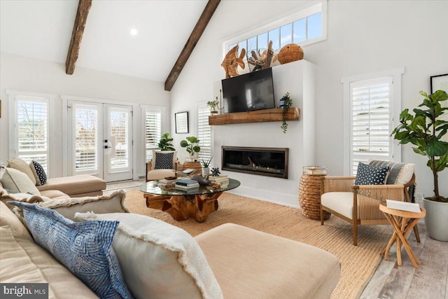 living room with high vaulted ceiling, beamed ceiling, a glass covered fireplace, wood finished floors, and french doors