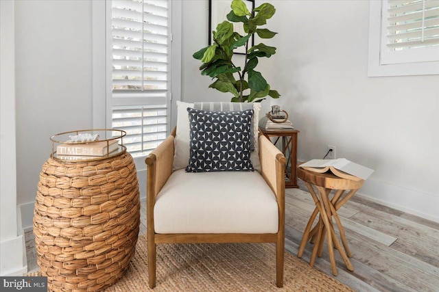 living area with a healthy amount of sunlight, wood finished floors, and baseboards
