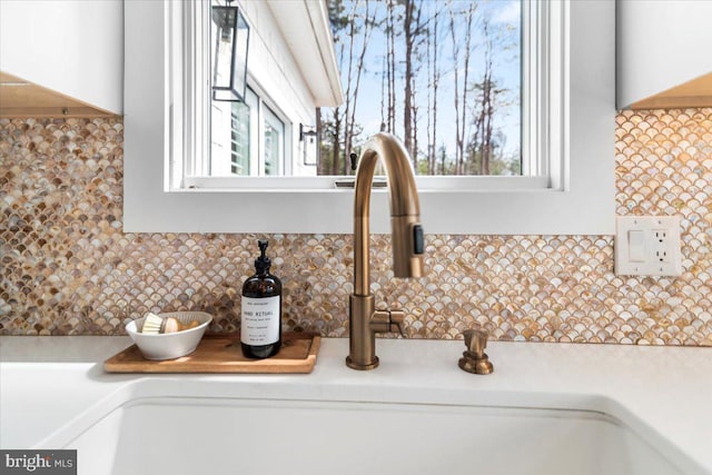 details with light countertops, decorative backsplash, and wall chimney exhaust hood