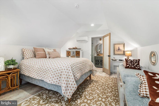 bedroom featuring light wood-type flooring, vaulted ceiling, and a wall mounted air conditioner