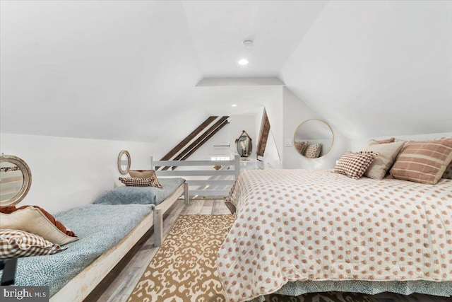 bedroom featuring wood finished floors and vaulted ceiling