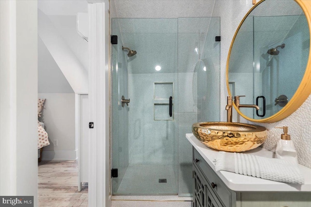bathroom featuring vanity, baseboards, a stall shower, and wood finished floors