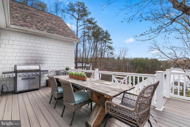 deck featuring outdoor dining space and a grill