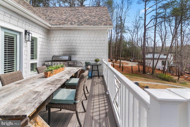 wooden terrace with grilling area and outdoor dining area