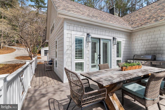 wooden terrace with grilling area and outdoor dining area