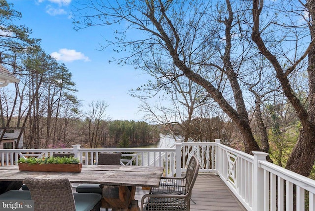 wooden deck featuring a water view and outdoor dining space