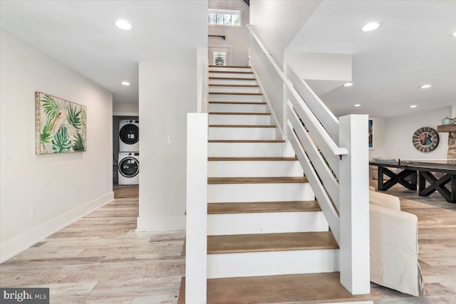 staircase featuring stacked washer and dryer, wood finished floors, baseboards, and recessed lighting