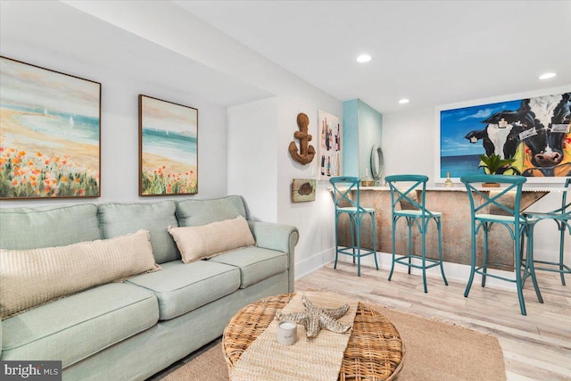 living room with wood finished floors, baseboards, and recessed lighting