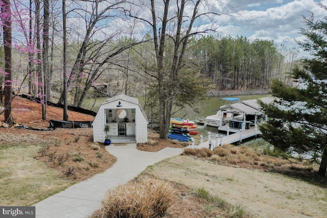 exterior space featuring a water view, a boat dock, and an outbuilding