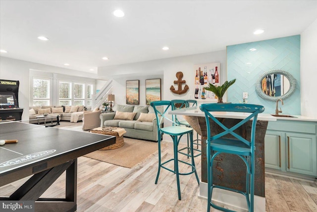 game room with light wood-style flooring, a sink, and recessed lighting