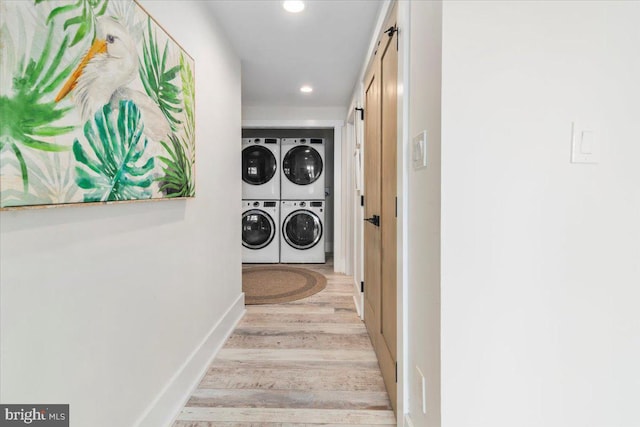 interior space featuring baseboards, stacked washer and clothes dryer, recessed lighting, a barn door, and wood finished floors