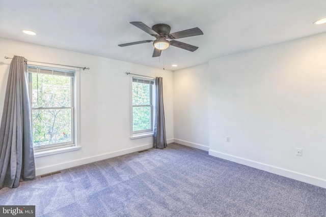 empty room with visible vents, baseboards, carpet floors, and ceiling fan