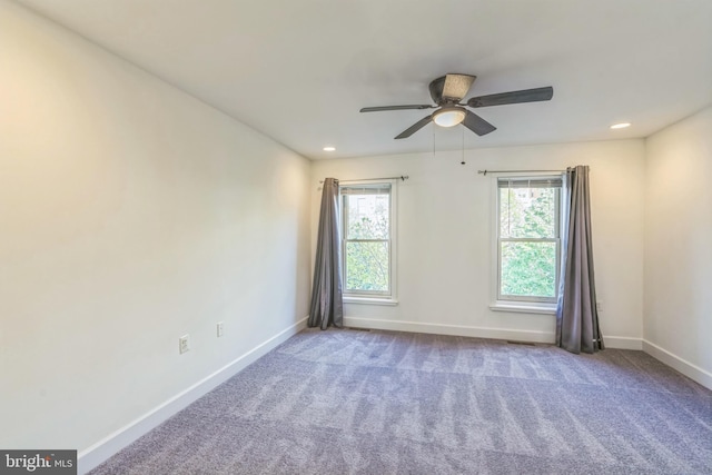 spare room featuring a healthy amount of sunlight, a ceiling fan, and baseboards