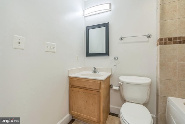 full bath with a tub to relax in, baseboards, vanity, and toilet